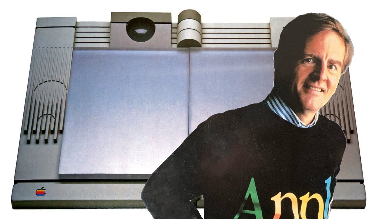 A person in a black sweater stands in front of a vintage computer featuring an Apple logo in the corner.