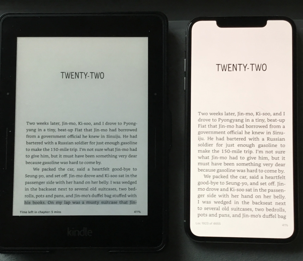 Photograph of a Kindle Voyage next to an iPhone XS Max, both displaying Kindle books