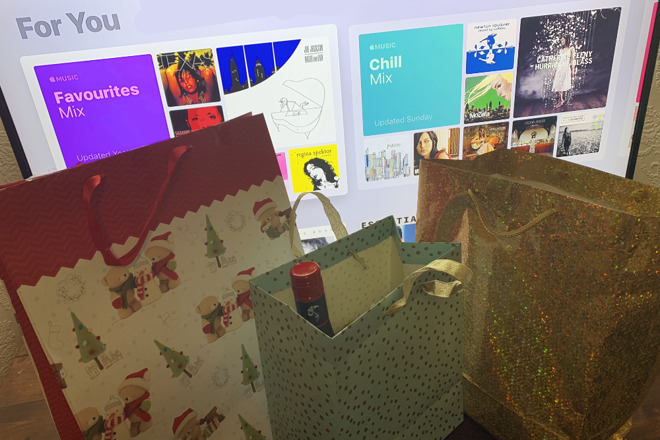 Gifts in front of a TV showing Apple Music