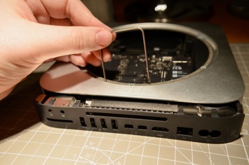 Pull the logic board removal tool towards the edge of the case and remove