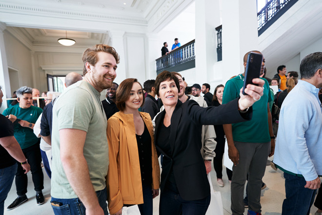 Apple retail VP Deirdre O'Brien posing with shoppers.