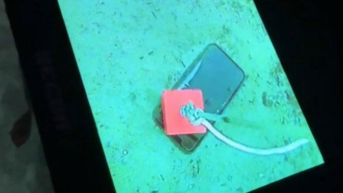 The iPhone seen through a fish finder being pulled up with a strong magnet