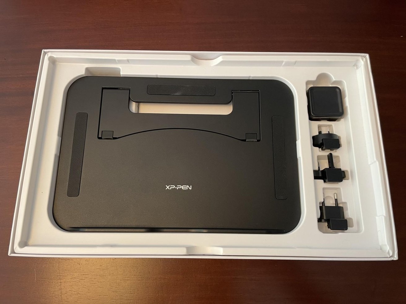 The box is tightly packed, with the stand and power adapter options included below the tablet itself. 