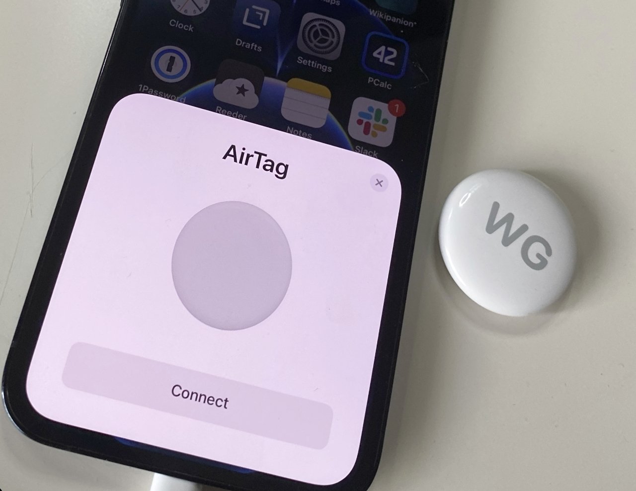 Pull the cover off your AirTag and then hold it next to your iPhone