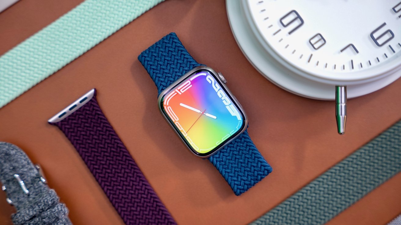 Apple Watch Series 7 with blue band surrounded by Apple Watch bands