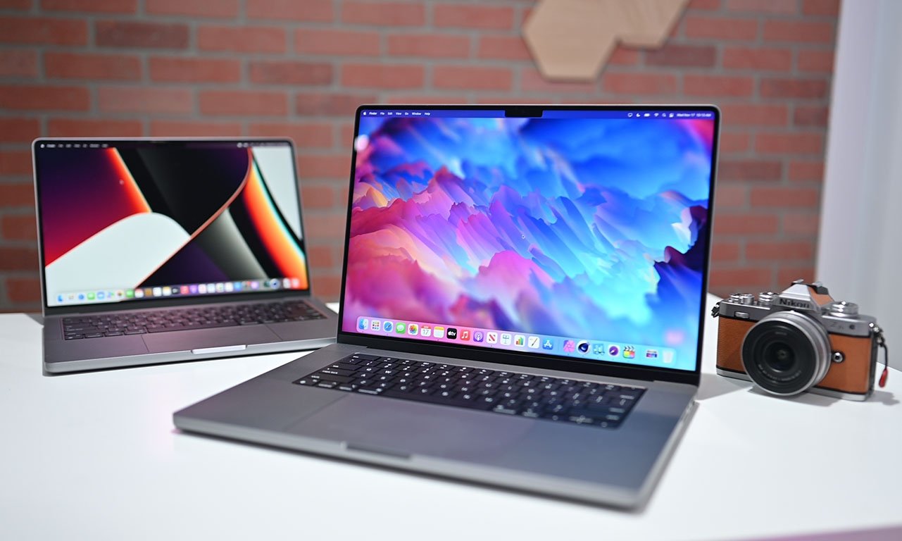 Apple 14-inch and 16-inch MacBook Pro on display with camera on desk