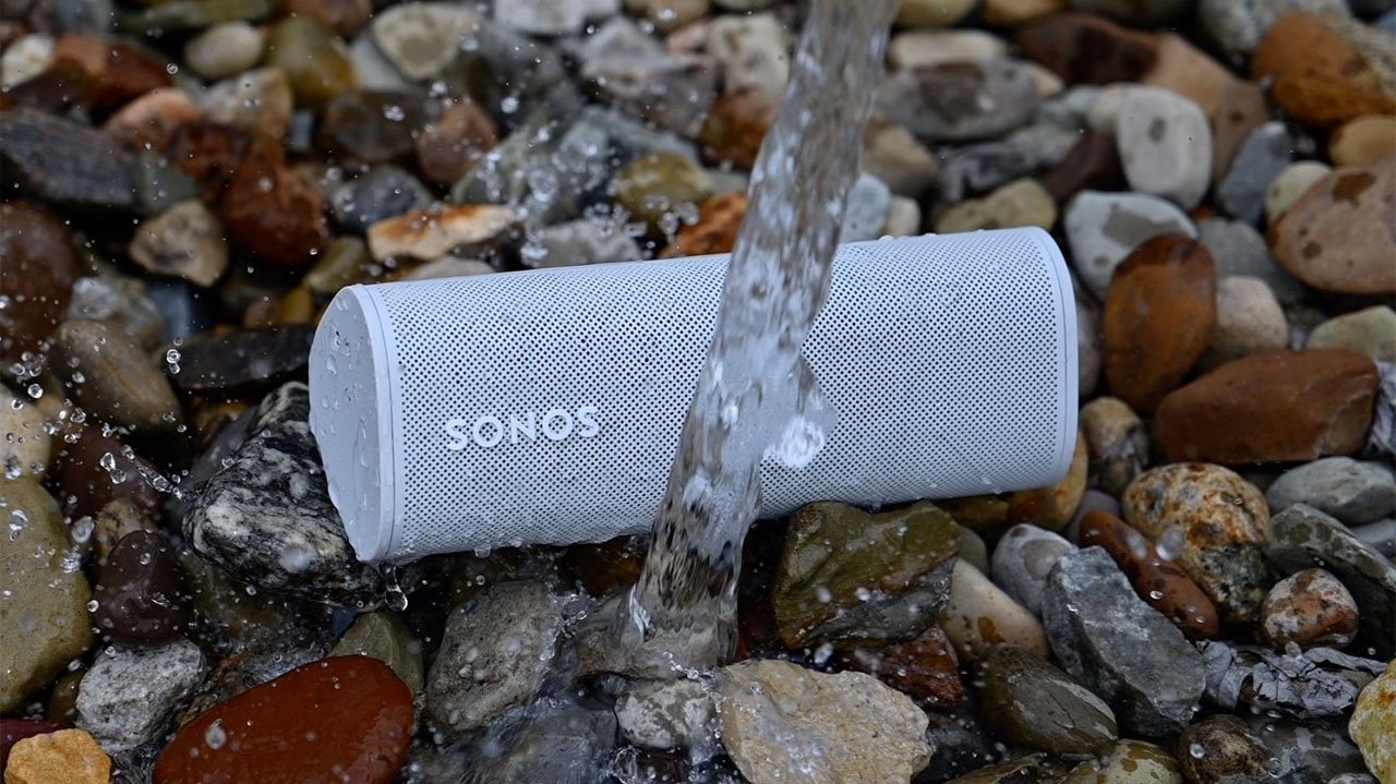 Sonos Roam portable speaker on rocks with stream of water