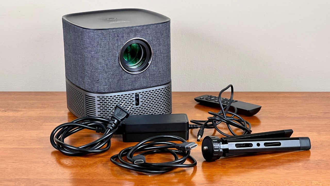The Mudix HP11 MX2 video projector comes with a remote control, an HDMI cable, a power adapter and cord, and a tripod stand