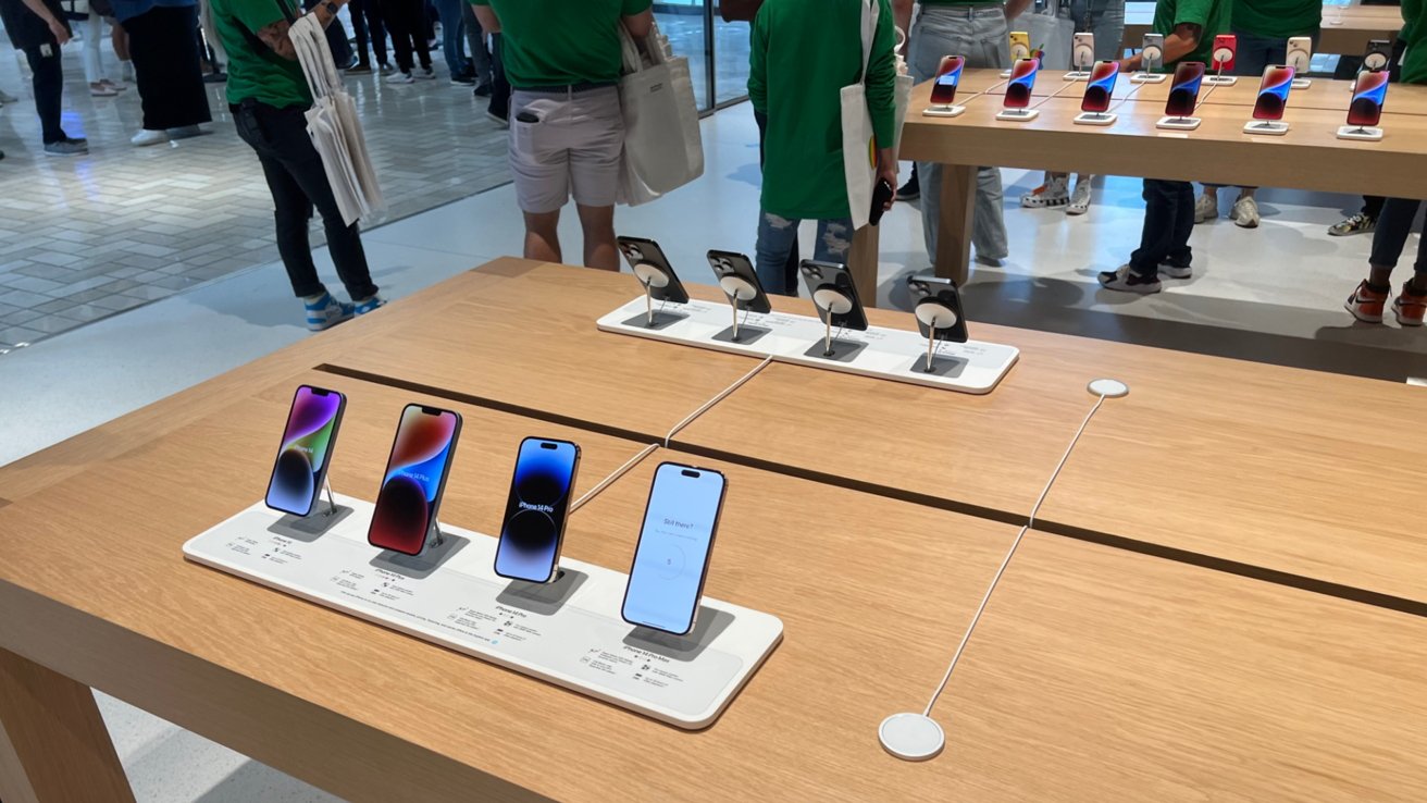 Wooden display tables surrounded by Apple employees