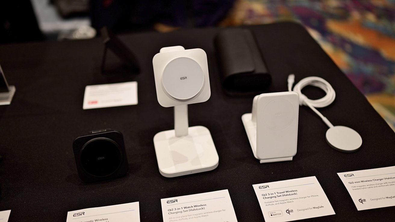A display of various ESR-branded charging devices and stands for phones and smartwatches on a table, with descriptive labels in front of each product.