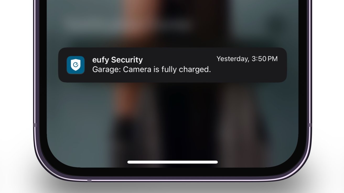 A smartphone screen displays a notification from 'eufy Security' stating 'Garage: Camera is fully charged', timestamped 'Yesterday, 3:50 PM'.