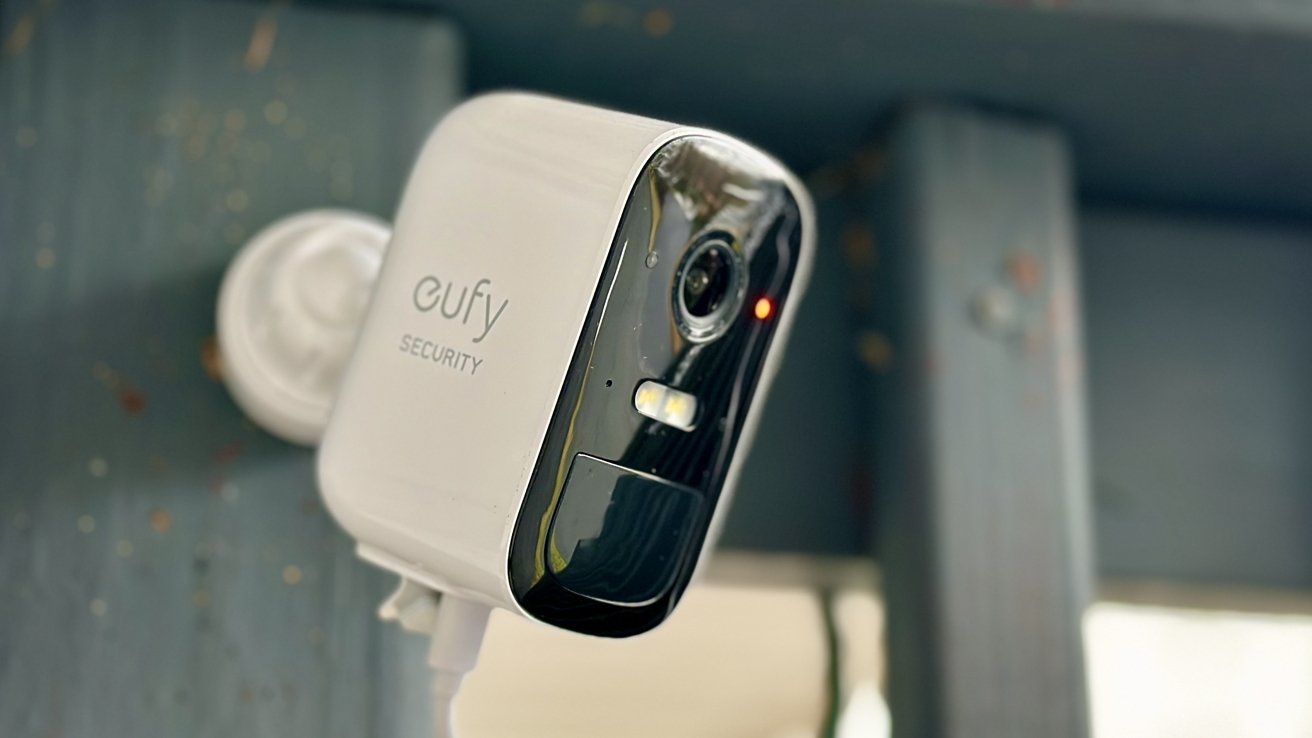 Close-up of a white Eufy security camera mounted on a wall, with a clear lens and sensors visible against a blurred background.