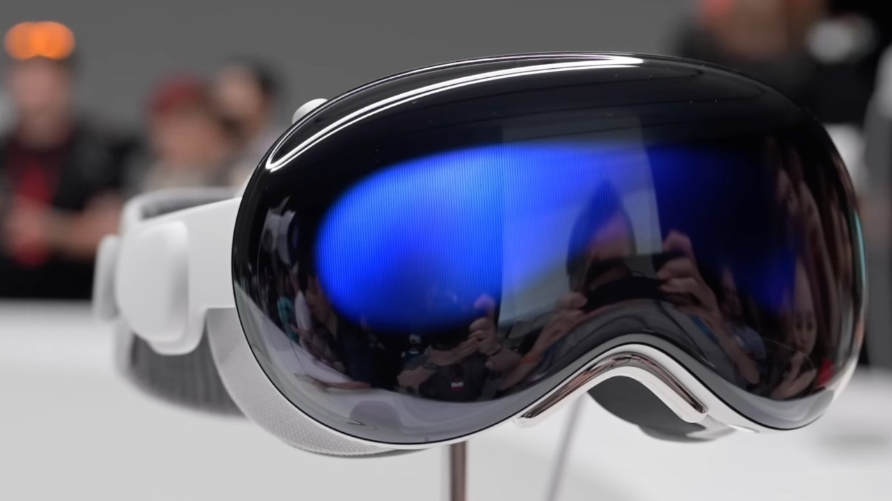 A sleek, black and white virtual reality headset displayed on a stand with blurred figures and bright colors reflected on its glossy surface.