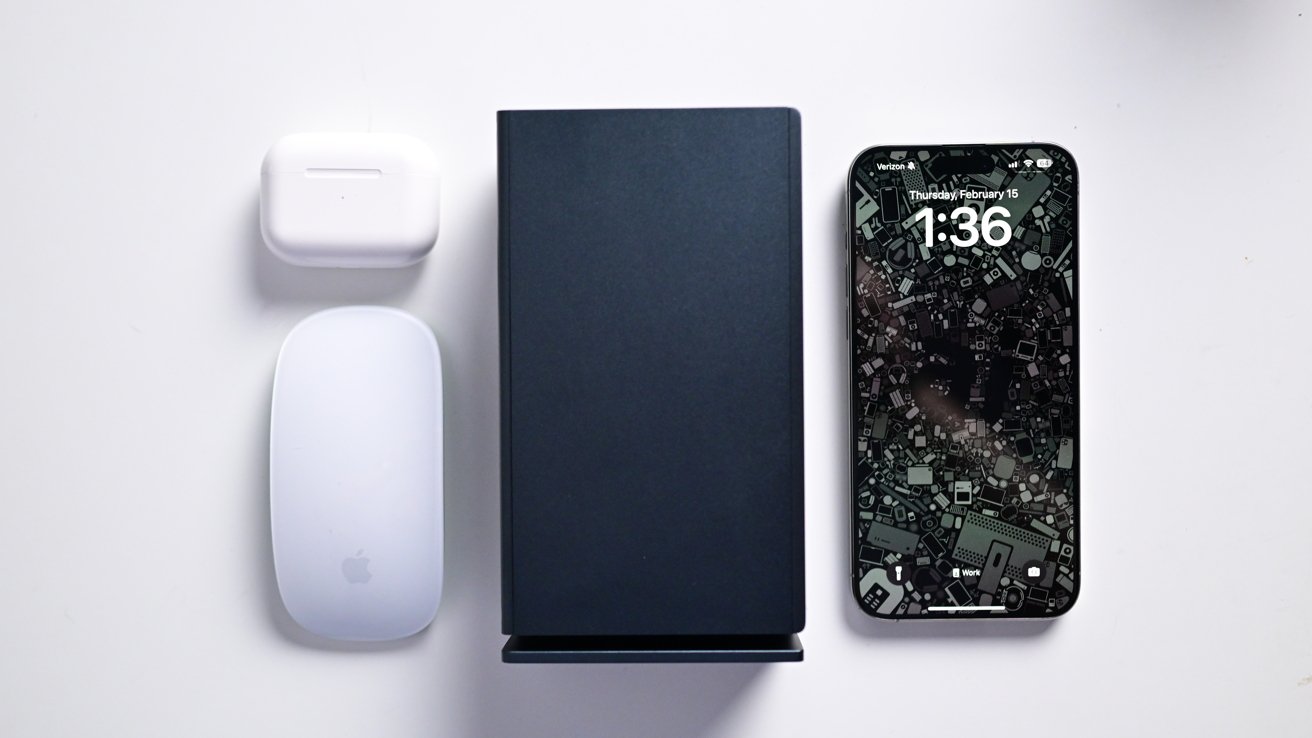 Ivanky FusionDock Max 1 on my desk compared to AirPods Pro, iPhone 15 Pro Max, and the Magic Mouse