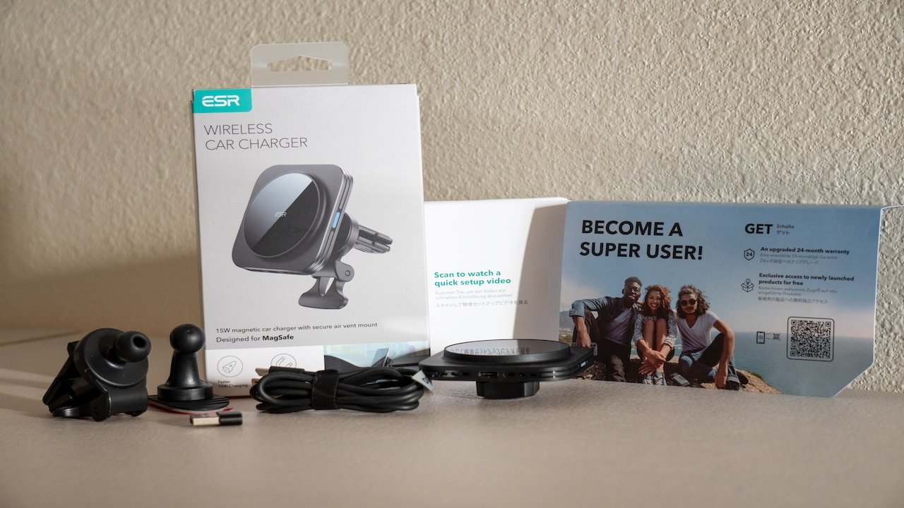 A wireless car charger, components, cables, and promotional leaflets with QR codes displayed on a table.