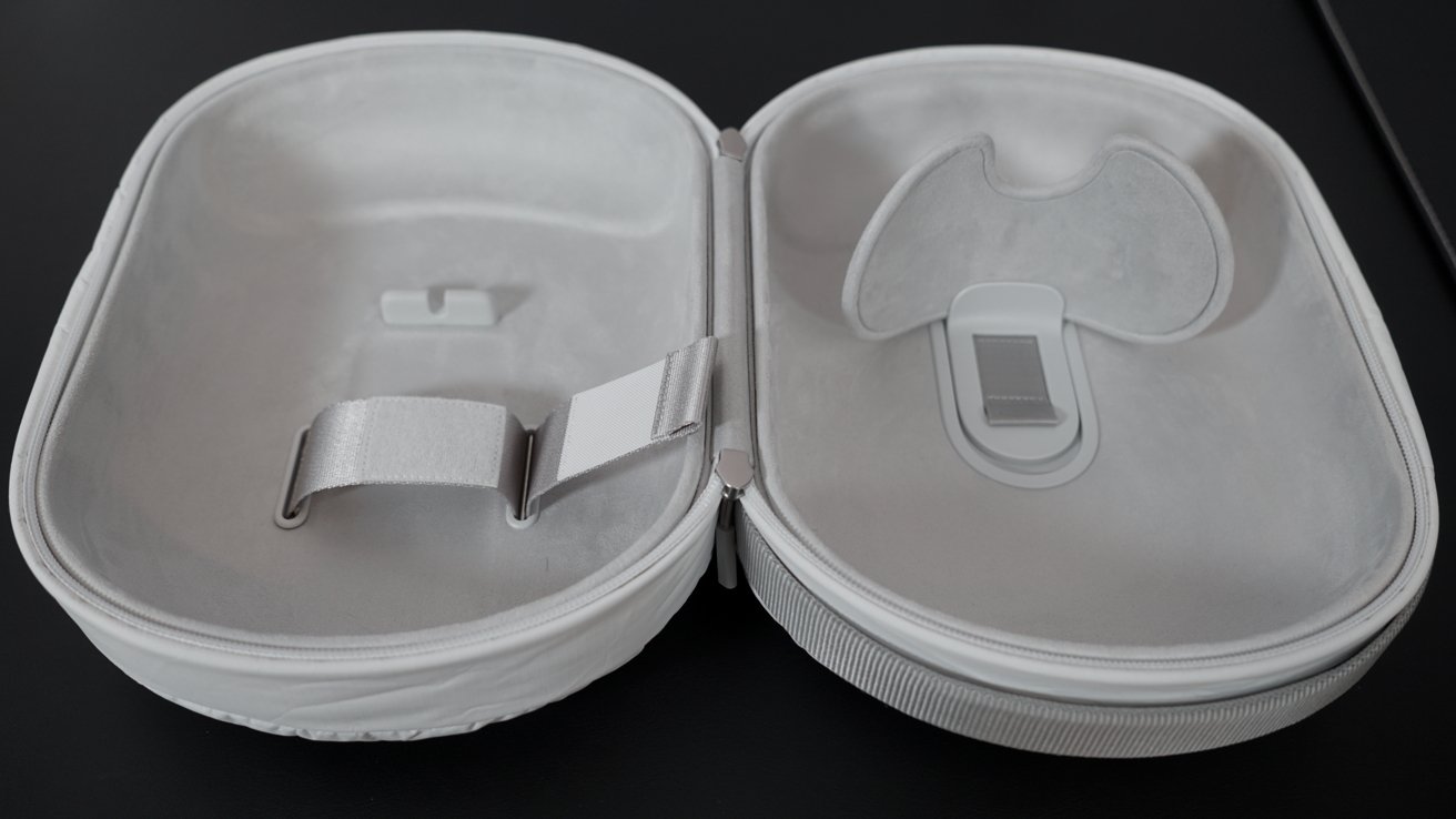 The Travel Case is open and empty on a table. The interior is visible with a soft fabric and molding for placing the headset.