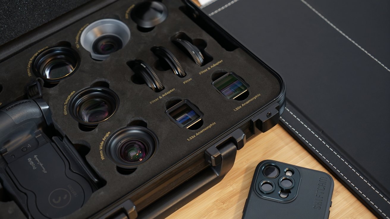 An iPhone laying next to an open case filled with camera lenses