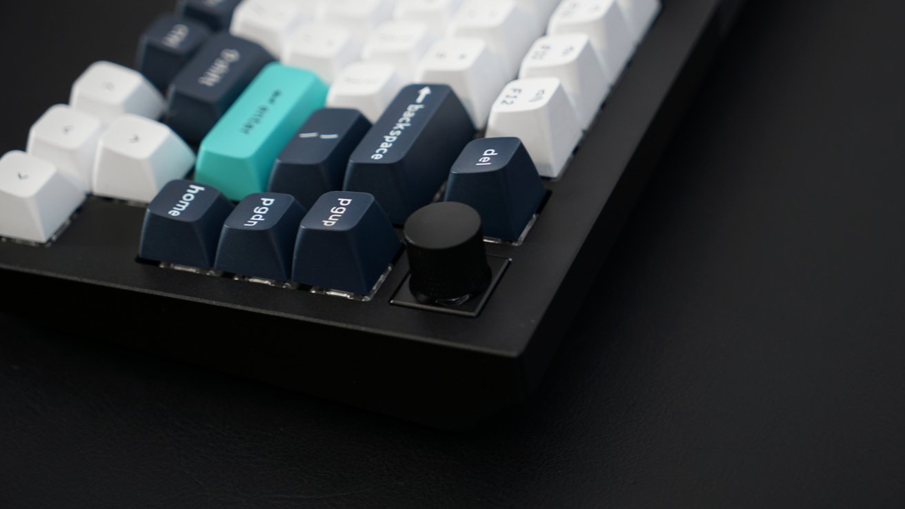 The rear corner of the mechanical keyboard with the volume knob in focus