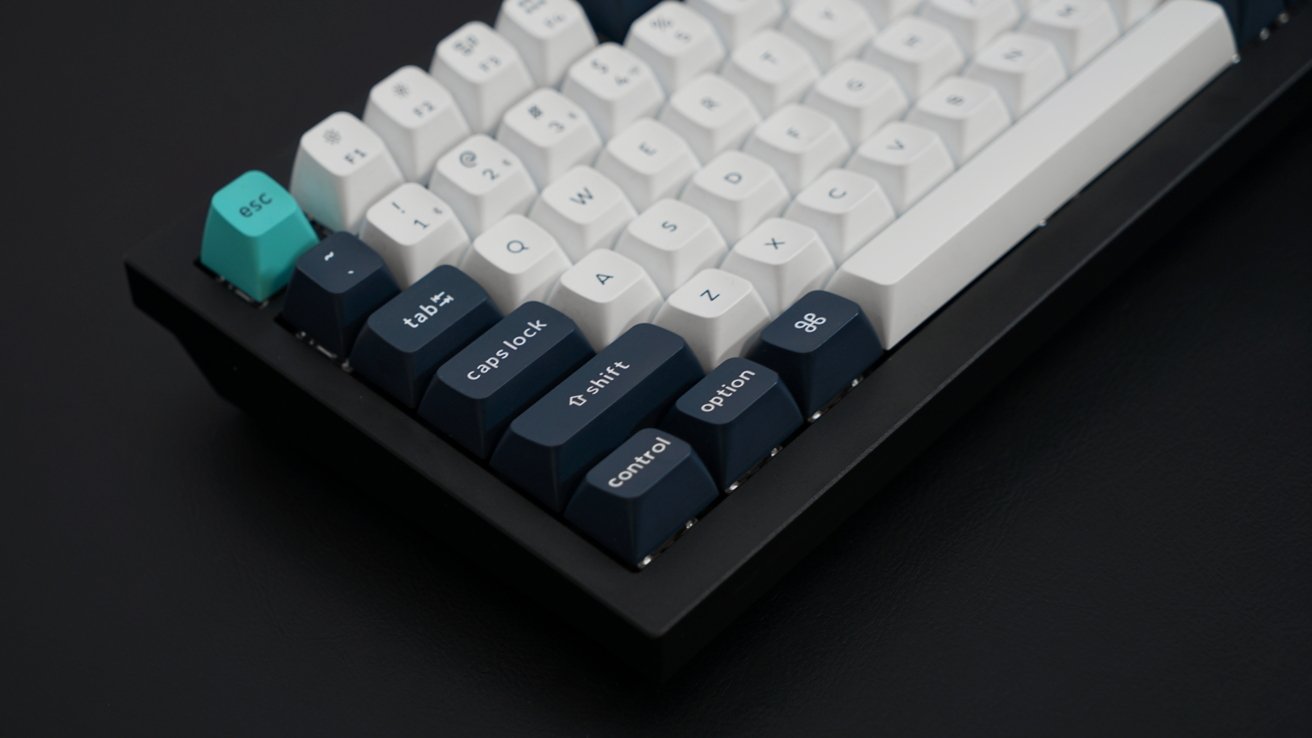 The bottom corner of the mechanical keyboard showing dark blue keys and white keys