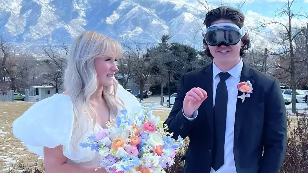 A bride in a white dress holding a bouquet and a groom wearing an Apple Vision Pro, with mountains in the background.
