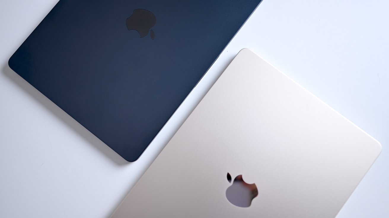 Two MacBook Air models, one dark blue and one silver, overlapping on a white surface.
