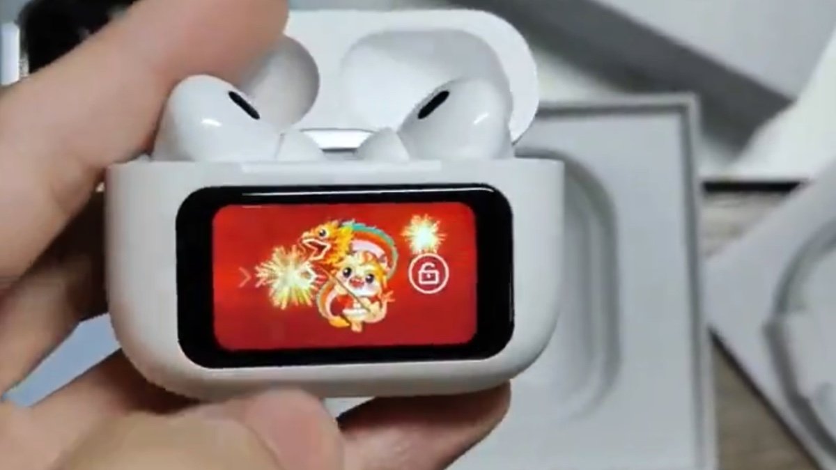 Hand holding open wireless earbud case displaying a colorful animated dragon on its small rectangular screen.