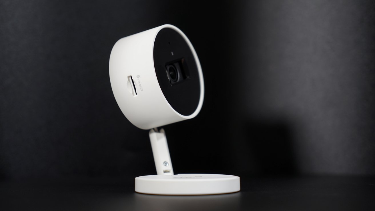 A home security camera with an adjustable neck and an SD card slot visible.