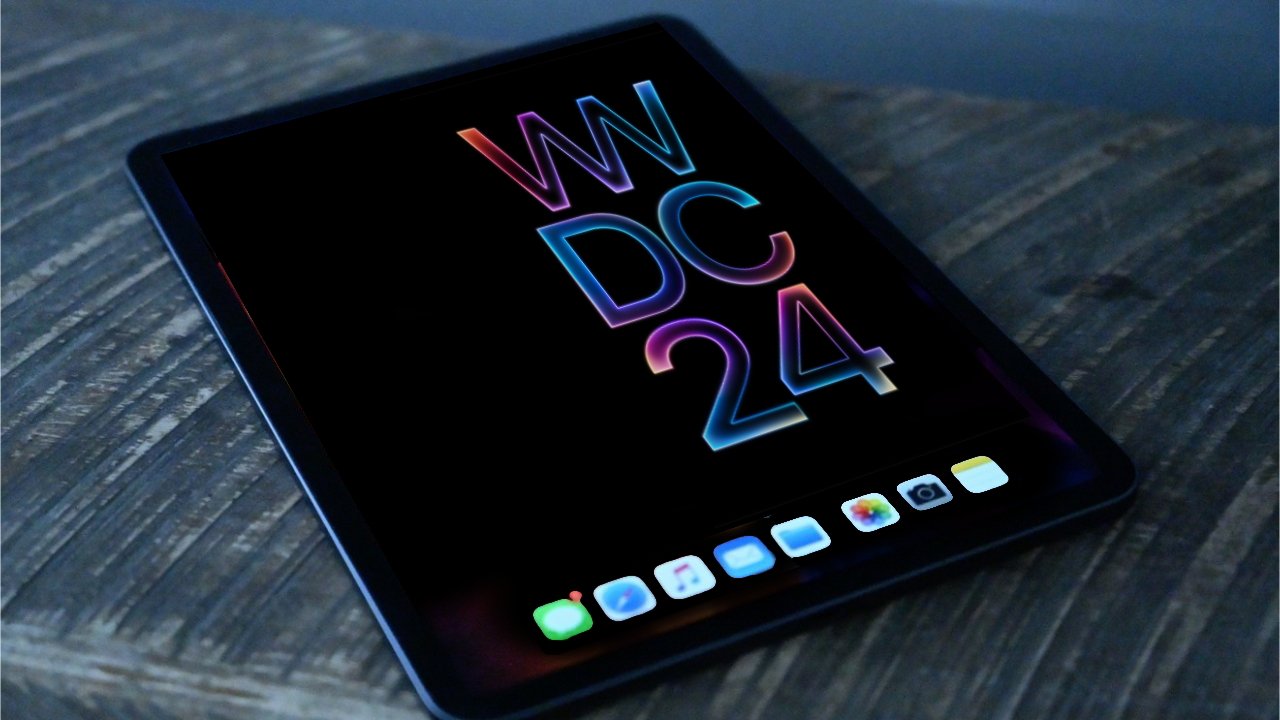 A tablet with colorful neon WWDC 24 logo on its screen, resting on a wooden surface.