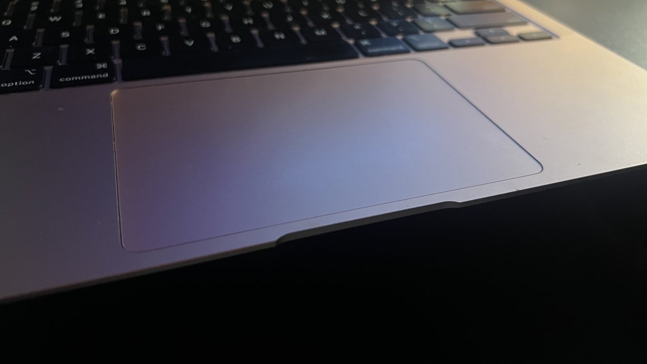 A picture of the trackpad on a rose gold Macbook Air, the keyboard above it is out of focus