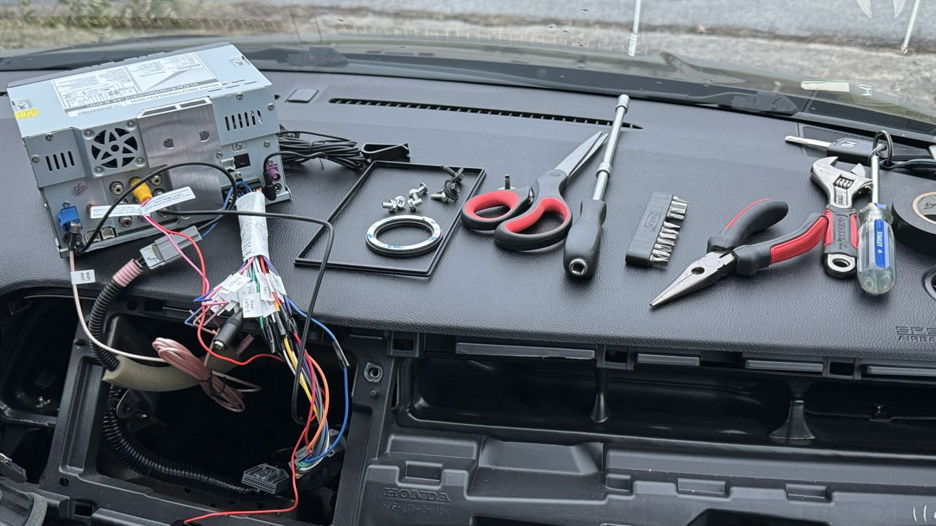 The Atoto S8 Pro on the dash of a car with cables out and tools around for installation.