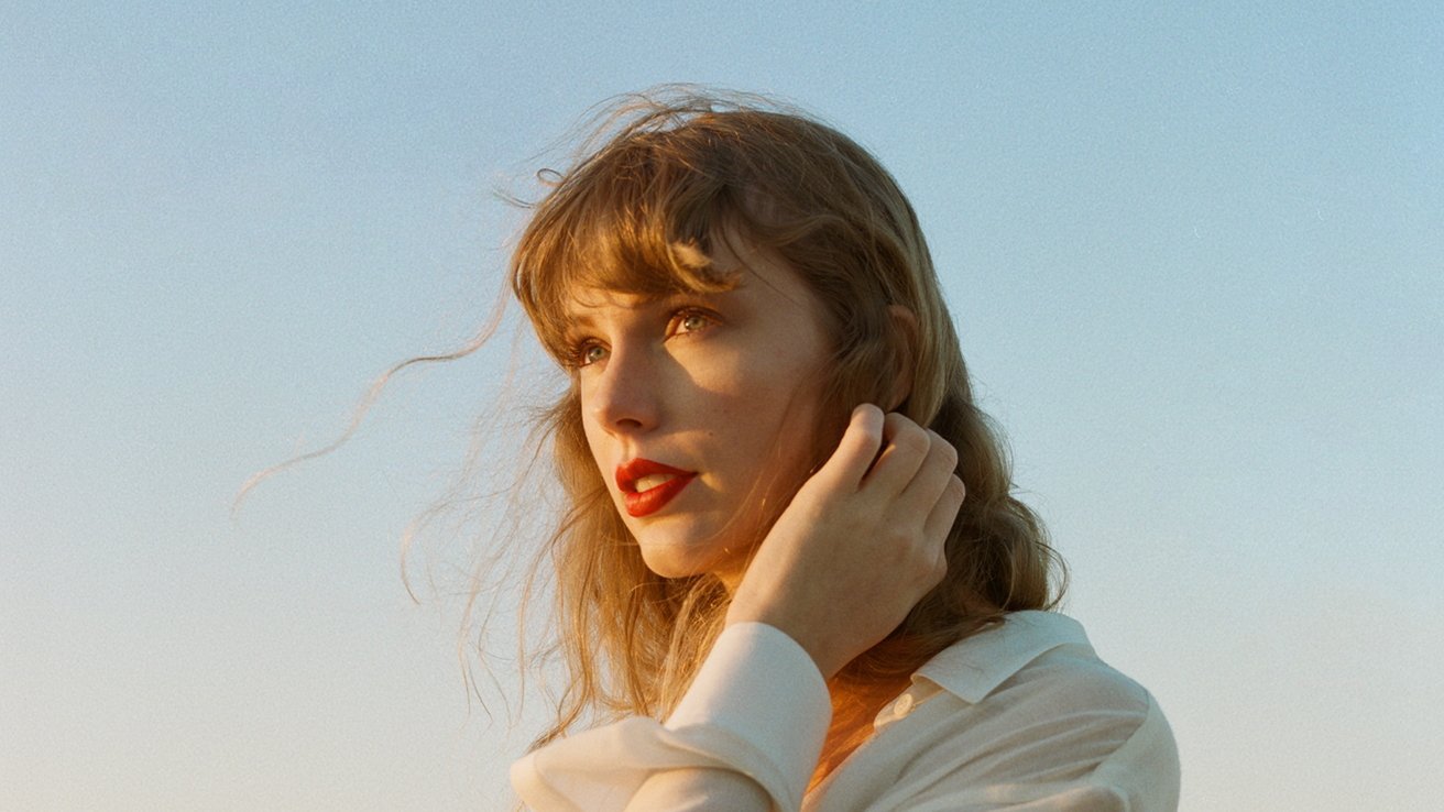Woman with red lipstick and windswept hair gazes into the distance against a clear sky at twilight.