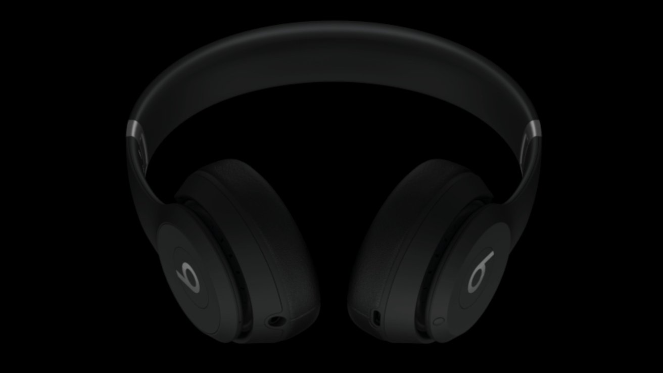 Black Beats over-ear headphones against a dark background, showing left and right earcups with logos.