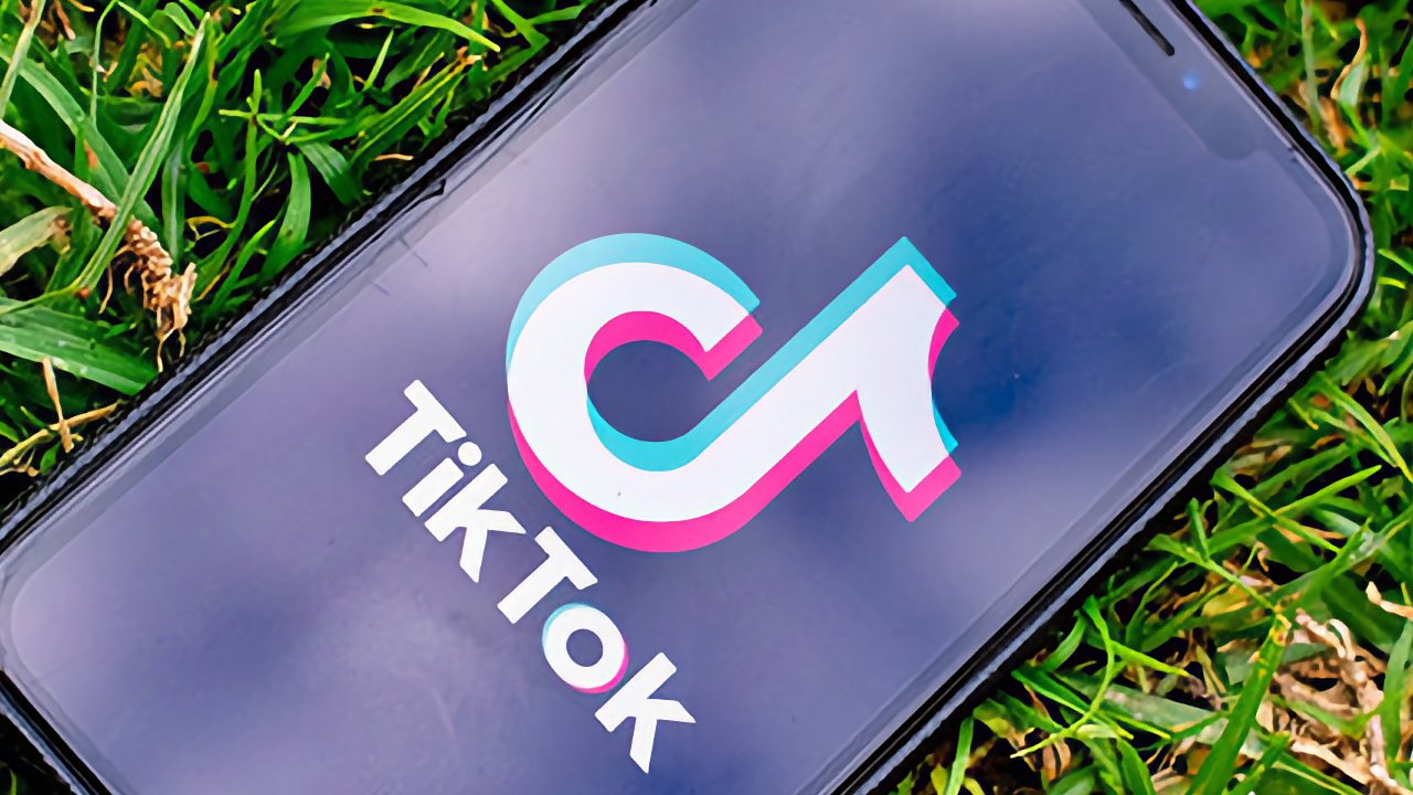 Smartphone lying on grass with TikTok logo on screen.