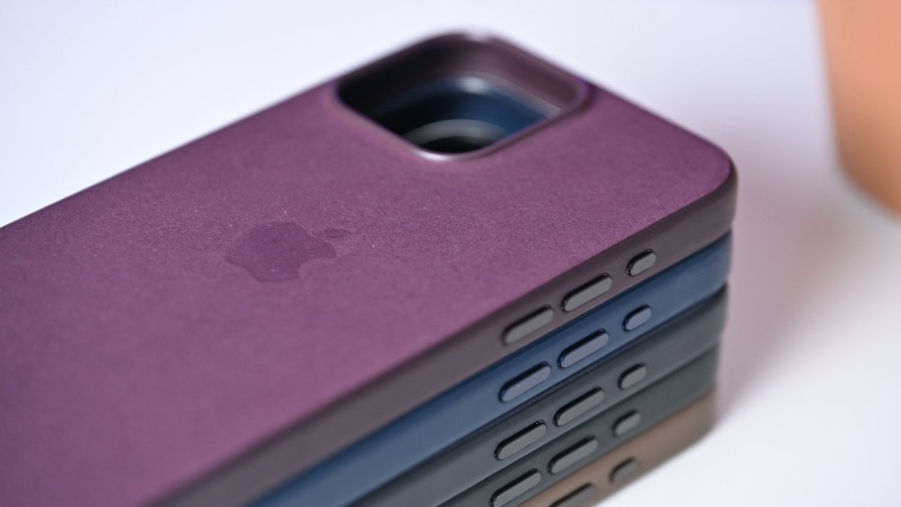 Close-up of a stack of smartphones cases showing camera cutouts and Apple logo, in varying shades of purple and blue.