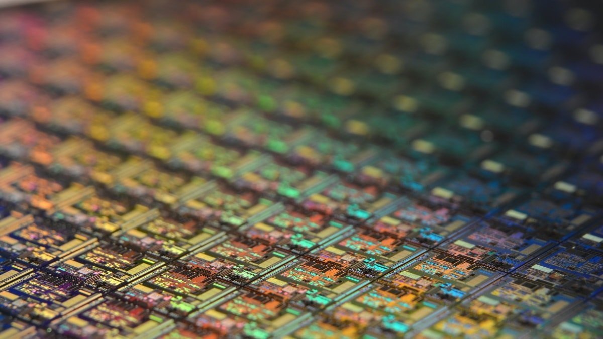 Close-up of a colorful semiconductor microchip with intricate patterns.