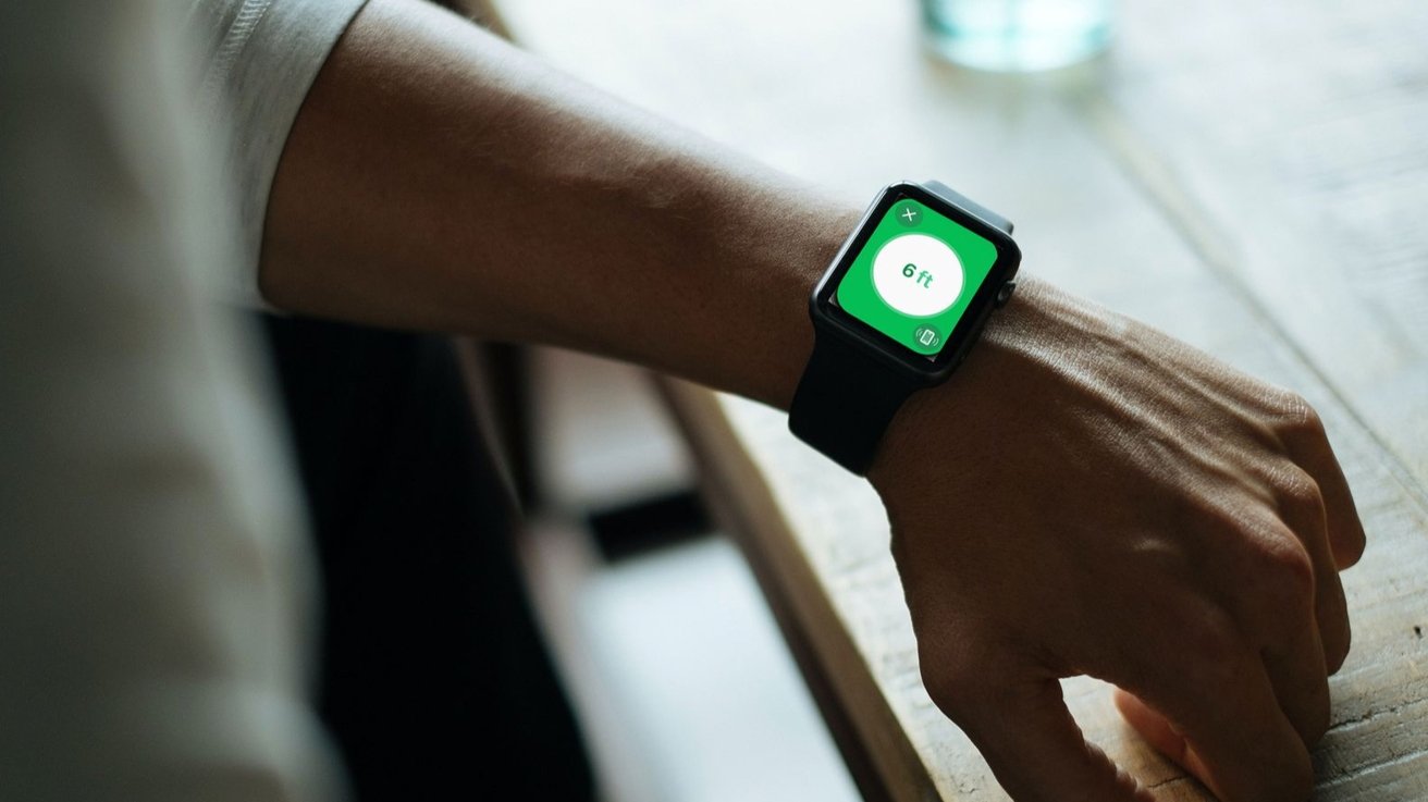 A person's wrist wearing an Apple Watch displaying '6 ft' on the screen, suggestive of social distancing guidance.