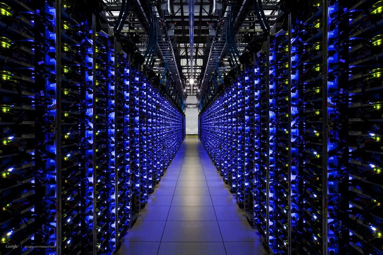 Rows of server racks in a data center illuminated by blue LED lights creating a corridor effect.