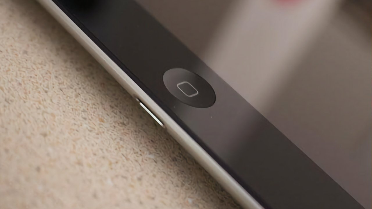 Close-up of a smartphone's home button on a textured surface.