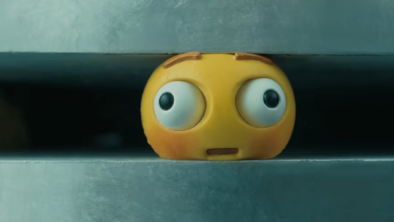 A surprised yellow animated character with big eyes peeking out from a narrow gap between gray metal surfaces.