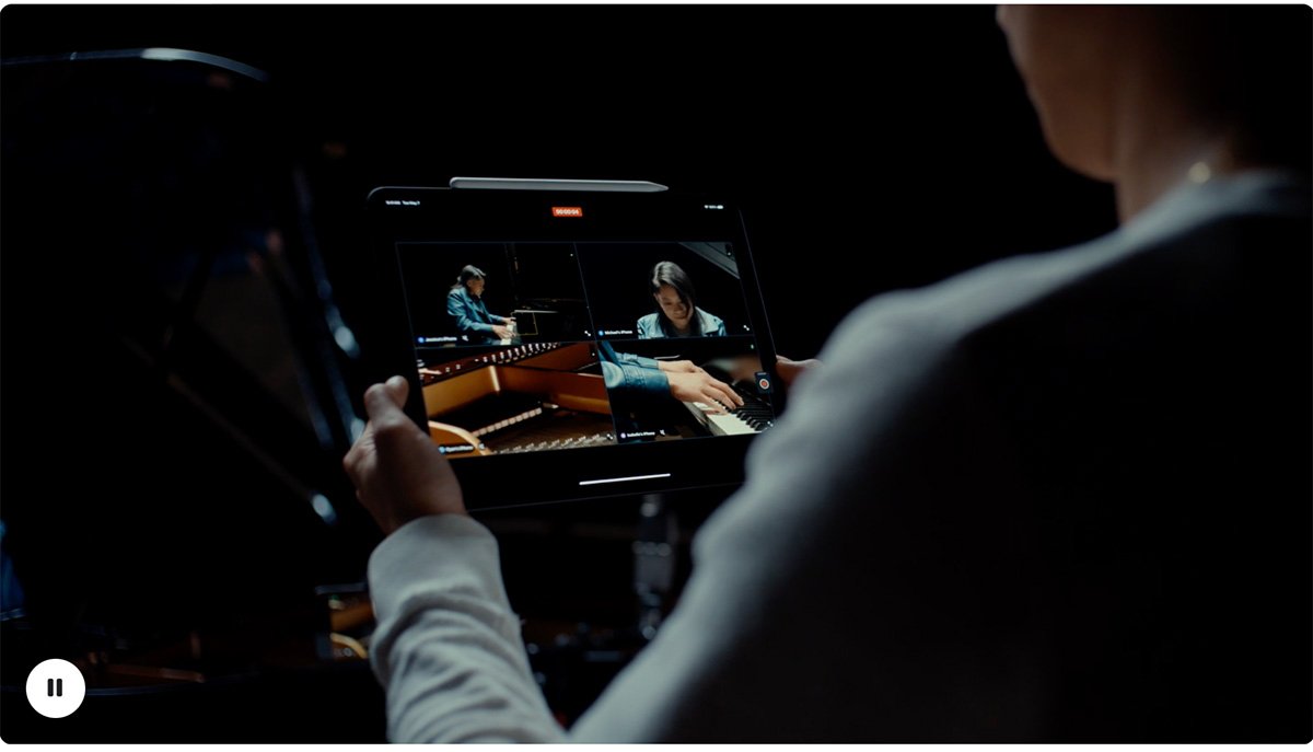Over-the-shoulder view of a person recording a piano performance on an iPad.