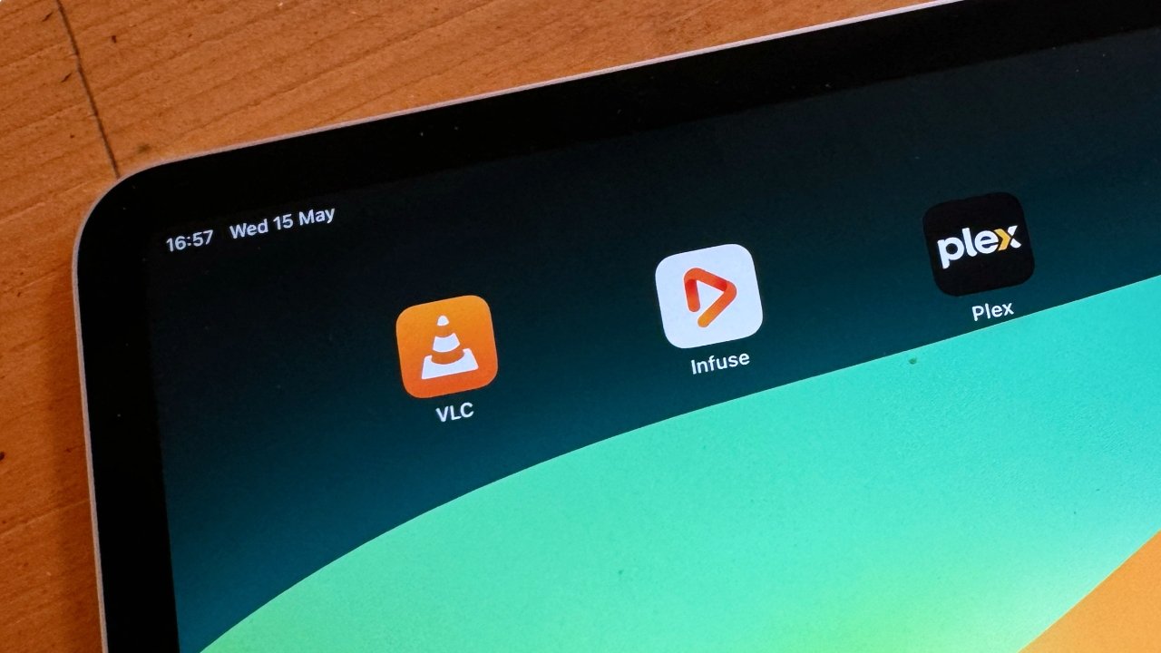 Close-up of a tablet corner displaying app icons including VLC, Infuse, and Plex on a colorful background.