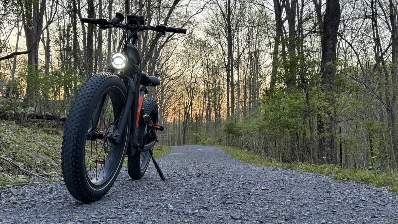 Heybike Hero on a trail as the sun sets, headlight on. Fat tires prominent from the low angle.