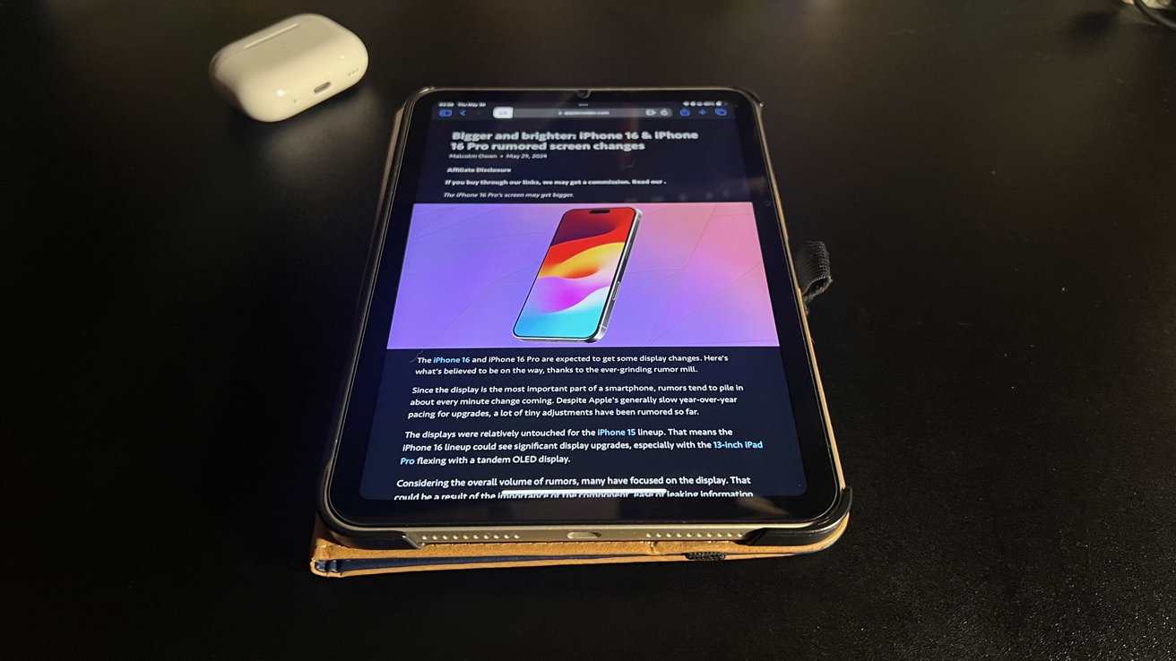 An iPad Mini sitting on a table, with an Apple Insider article opened in Reader Mode.