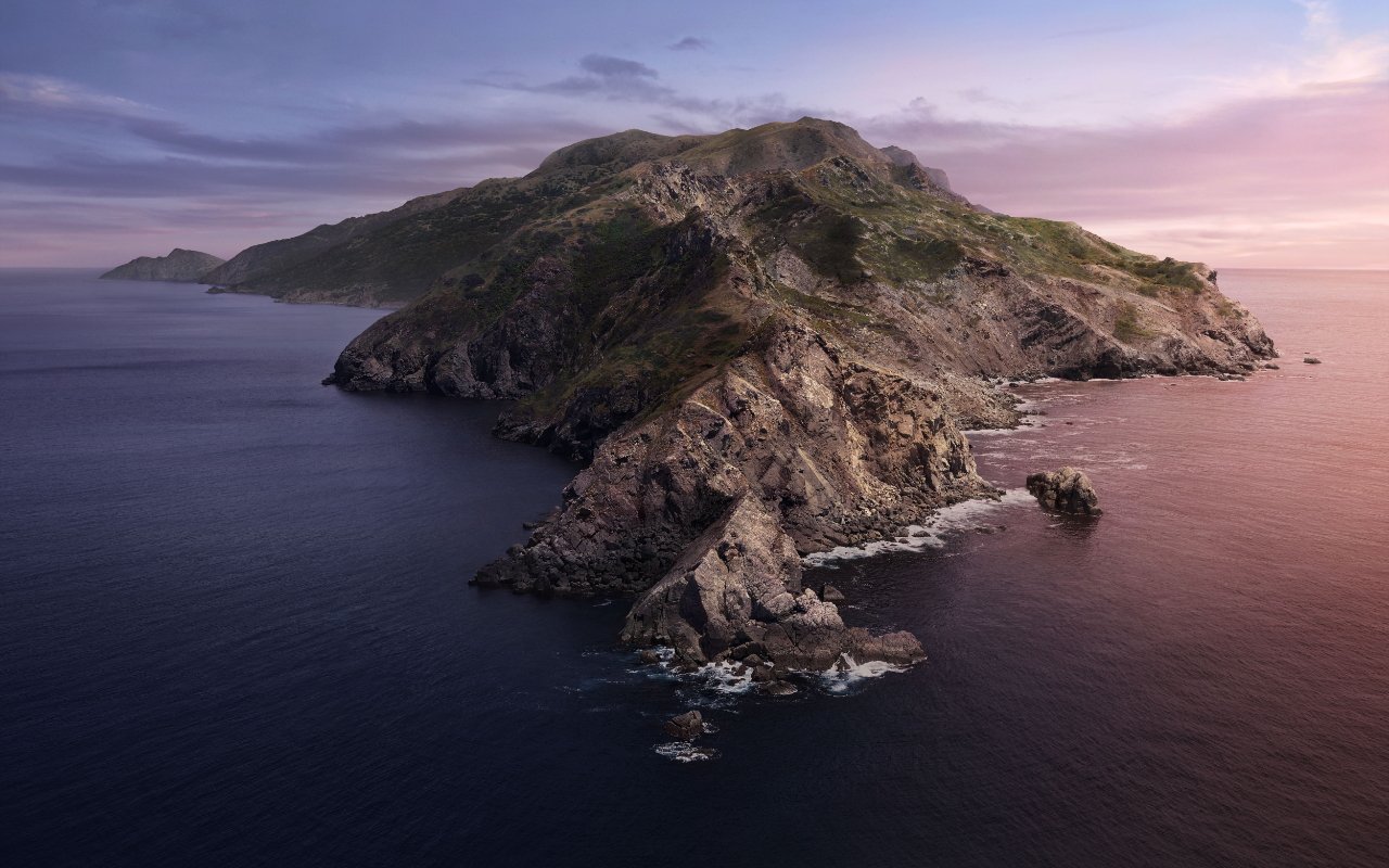 Rocky island surrounded by calm ocean water, cliffs covered in green vegetation, pastel sky at dusk with a peaceful horizon.