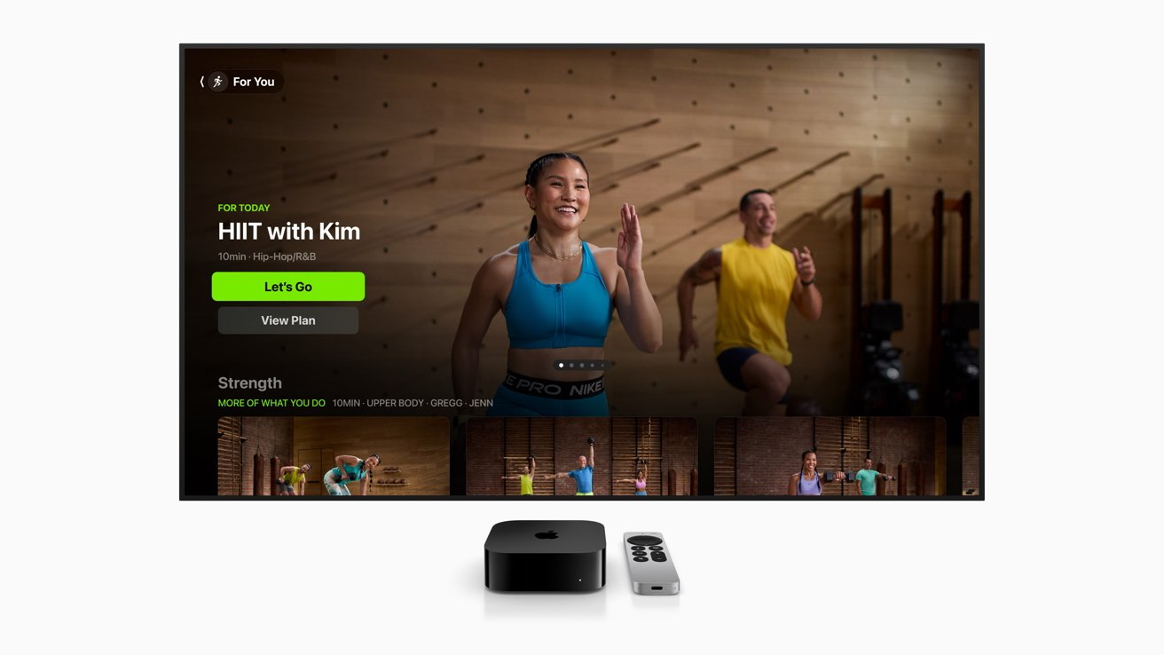 Person in a blue sports bra leading a fitness class with a 'Let's Go' button below. Apple TV and remote displayed underneath the screen.