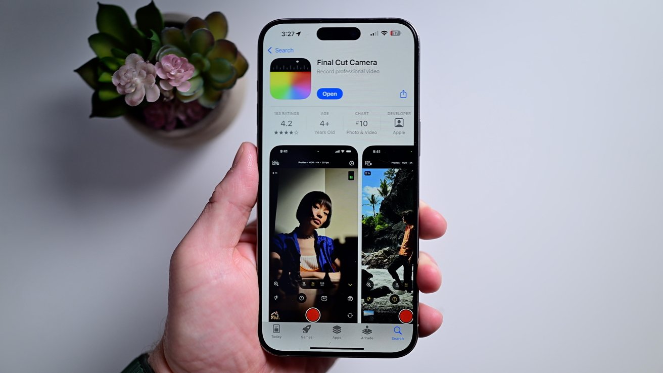 A person holding an iPhone above a white table with the Final Cut Camera App Store page on-screen