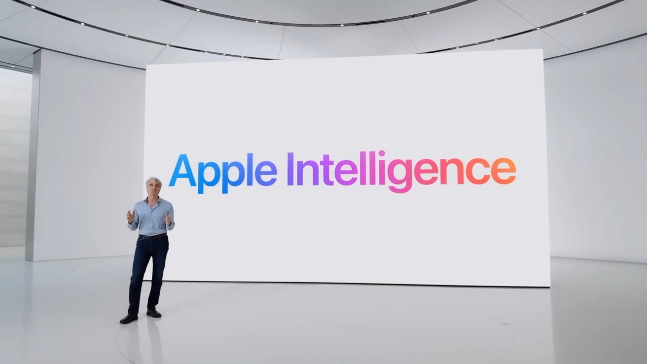Craig Federighi standing in front of a large screen with 'Apple Intelligence' in colorful letters, inside a modern, minimalistic room.