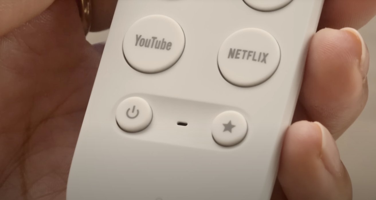 Hand holding a remote control with YouTube, Netflix, power, and star buttons.