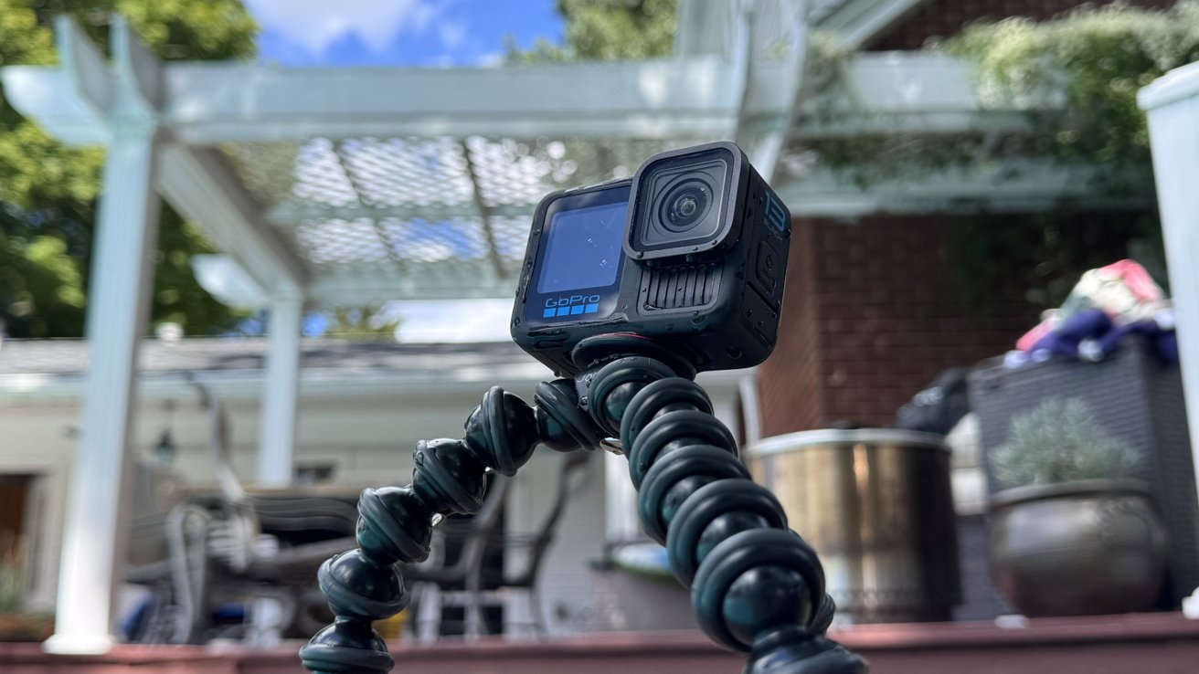 The GoPro Hero 13 Black action cam on a flexible tripod sitting by a pool