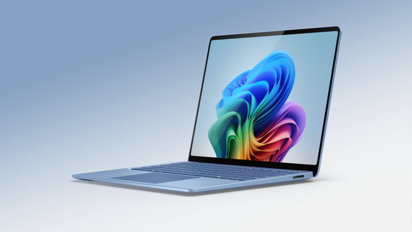 A sleek, open laptop with a colorful abstract pattern displayed on its screen, set against a gradient blue background.